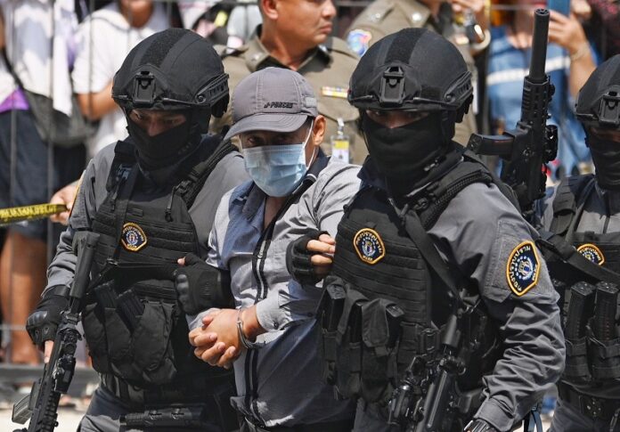 Prasittichai Khaokaew is escorted by police commandos to a police station in Lopburi on Jan. 22, 2020. Prasittichai Khaokaew is escorted by police commandos to a police station in Lopburi on Jan. 22, 2020.