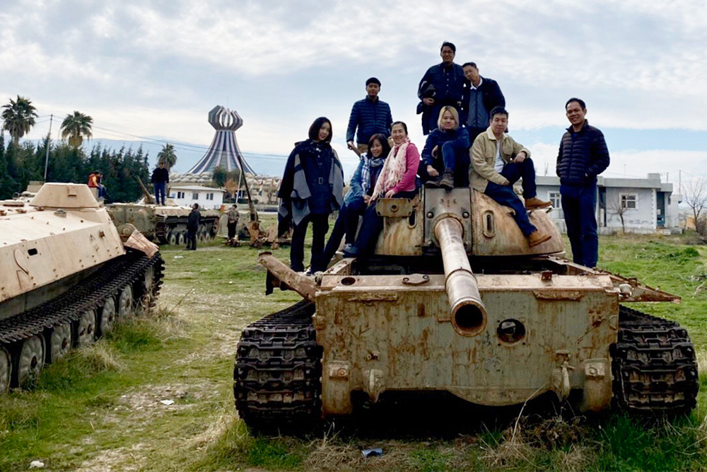 Pongsorn and his tour members pose with a wrecked tank in Iraqi Kurdistan. Photo: Pongsorn Bhumiwat / Courtesy