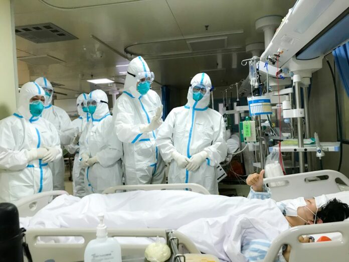 Members of the medical team of the Second Military Medical University receive praise from a patient at Hankou Hospital in Wuhan, central China's Hubei Province, Jan. 27, 2020. (Photo by Chen Jing/Xinhua)