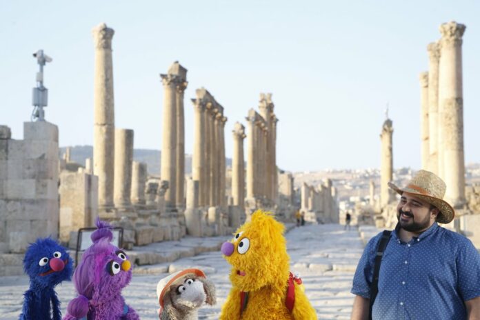 This image released by Sesame Workshop shows, from left, Grover, Basma, Ma'zooza and Jad with Rami Delshad, who portrays Hadi in