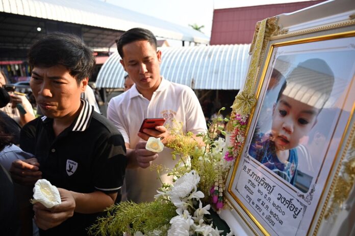 Mourners on Jan. 13, 2020, attend a cremation ceremony of a 2-year-old boy killed in the Jan. 9, 2020, gold store robbery in Lopburi province.