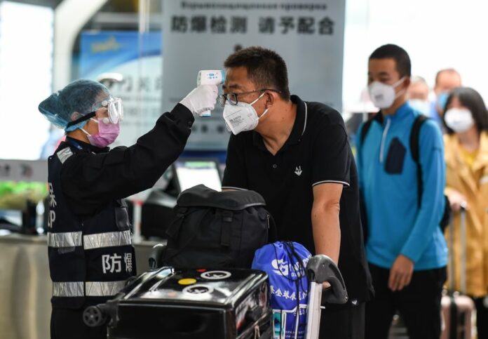 A security staff member checks a passenger's temperature at Sanya Phoenix International Airport in Sanya, south China's Hainan Province, Jan. 27, 2020. (Xinhua/Pu Xiaoxu)