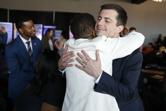 Democratic presidential candidate former South Bend Mayor Pete Buttigieg embraces Hannah Brown at the Nevada Black Legislative Caucus Black History Awards brunch Sunday, Feb. 16, 2020, in Las Vegas. (AP Photo/John Locher)