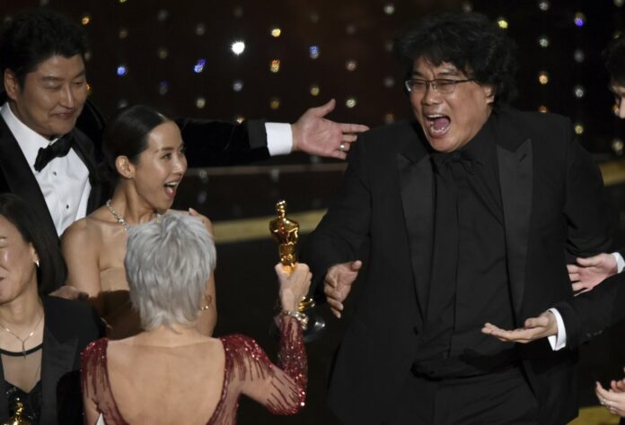 Bong Joon Ho, right, reacts as he is presented with the award for best picture for