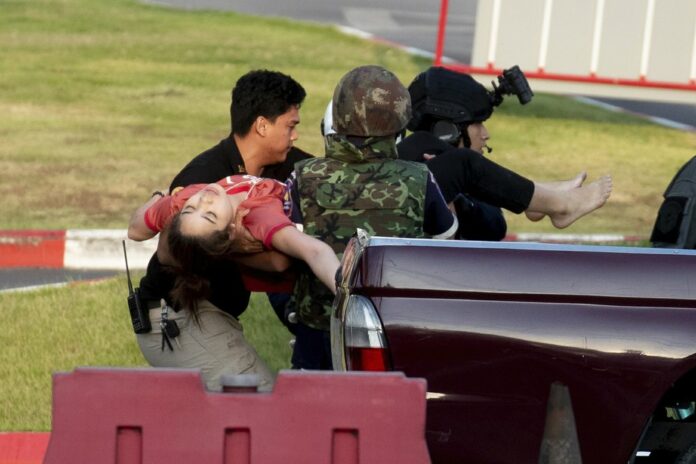 Armed commando soldiers carry a person out of Terminal 21 Korat mall in Nakhon Ratchasima, Thailand, Sunday, Feb. 9, 2020. (AP Photo/WasonWanichakorn)