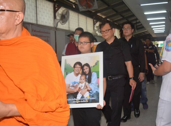 Families of victims killed in the Korat massacre carry their portrait during a religious ceremony on Feb. 11, 2020.