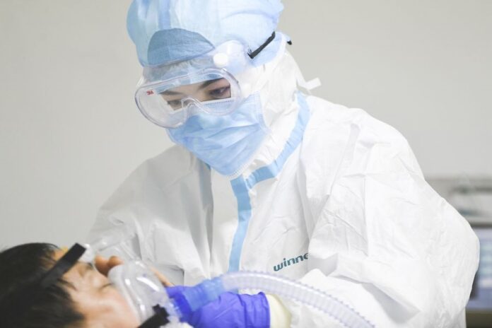 A medical staff member measures the temperature of his colleague at the First Affiliated Hospital of Zhejiang University's School of Medicine in Hangzhou, east China's Zhejiang Province, Jan. 27, 2020. (Xinhua/Huang Zongzhi)