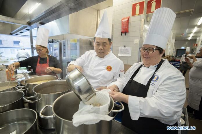 Sun Minghai (2nd R, front), member of the Chinese Cuisine Association and Ulla Liukkonen (1st R, front), Chairwoman of Finnish Chef Association, prepare dinner during Finland Chinese Food Night at the Main Post Office Restaurant in Helsinki, Finland, on Oct. 14, 2019. (Photo by Matti Matikainen/Xinhua)