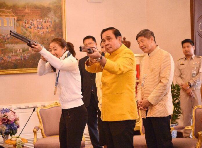 PM Prayut Chan-o-cha aims a shotgun alongside shooting athlete Sutiya Jiewchaloemmit at Government House on May 15, 2016. Image: Government House