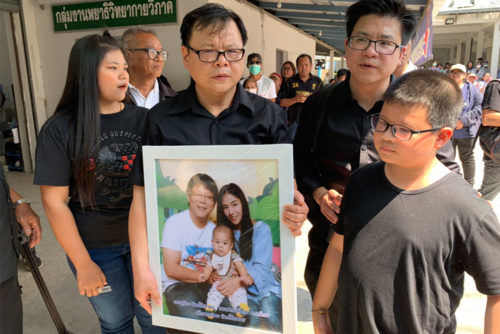 Relatives of Limratchataporns holding their funeral photo on Feb. 11.