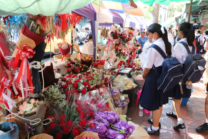 Students shop for bouquets of roses sold at the Flowers Market in Bangkok on Feb. 13, 2020.