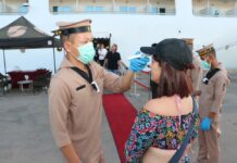 Gov’t Defends Allowing a HK Cruise to Dock, Rejecting Another A Royal Thai Navy sailor checks a passenger's temperature at Phuket Port on Feb. 13, 2020.