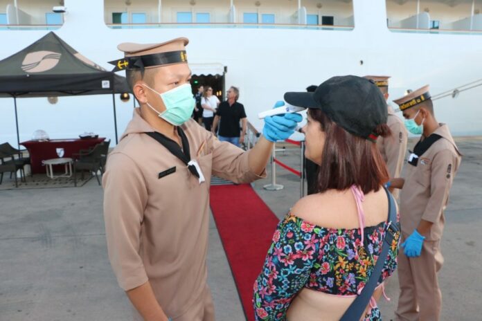 A Royal Thai Navy sailor checks a passenger's temperature at Phuket Port on Feb. 13, 2020.