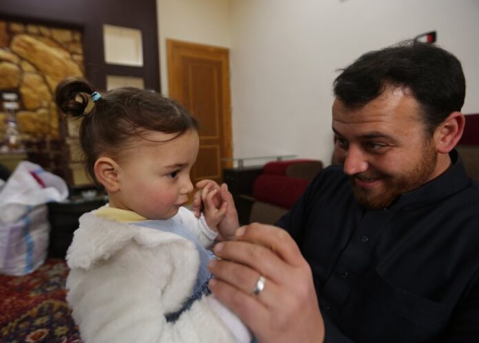 In this Sunday, Feb. 23, 2020 photo, Abdullah Mohammed plays with his daughter, three-year-old Salwa inside a house he recently fled to, near the Syrian-Turkish border, in Sarmada, Syria. (AP Photo/Ghaith Alsayed)