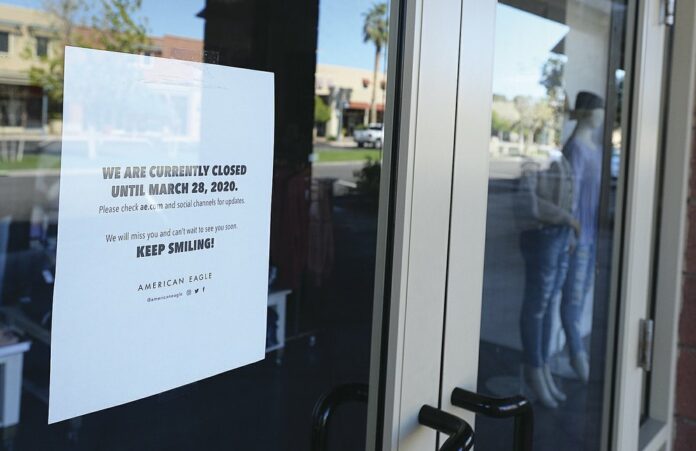 A sign on the door to American Eagle in The Village inside the Yuma Palms Regional Center states the store is closed until March 28, due to coronavirus and to