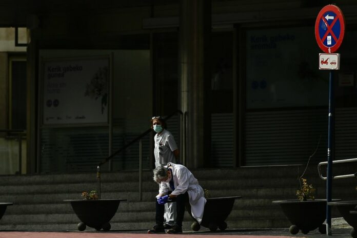 In this Friday March 20, 2020 file photo, health services staff members protest outside the Txagorritxu hospital demanding more protection equipment in a hospital, in Vitoria, northern Spain. (AP Photo/Alvaro Barrientos, File)