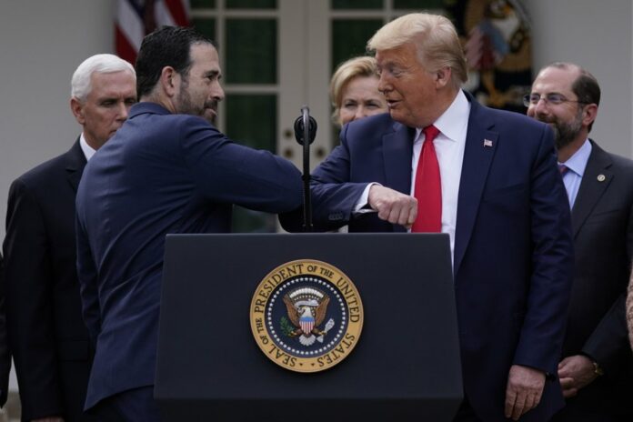LHC Group’s Bruce Greenstein elbow bumps with President Donald Trump during a news conference about the coronavirus in the Rose Garden at the White House, Friday, March 13, 2020, in Washington. (AP Photo/Evan Vucci)