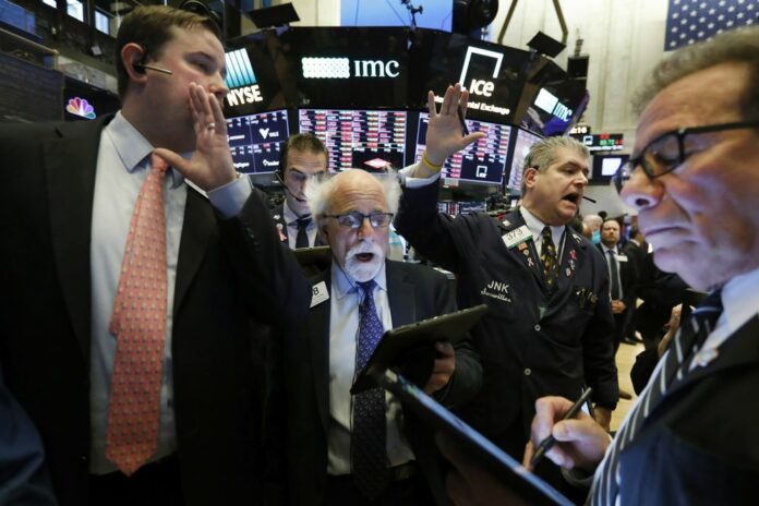 New York Stock Exchange Floor Governor Brendan Connolly, left, works with traders Peter Tuchman, John Panin and Sal Suarino, second left to right, on the floor of the NYSE, Monday, March 9, 2020. (AP Photo/Richard Drew)