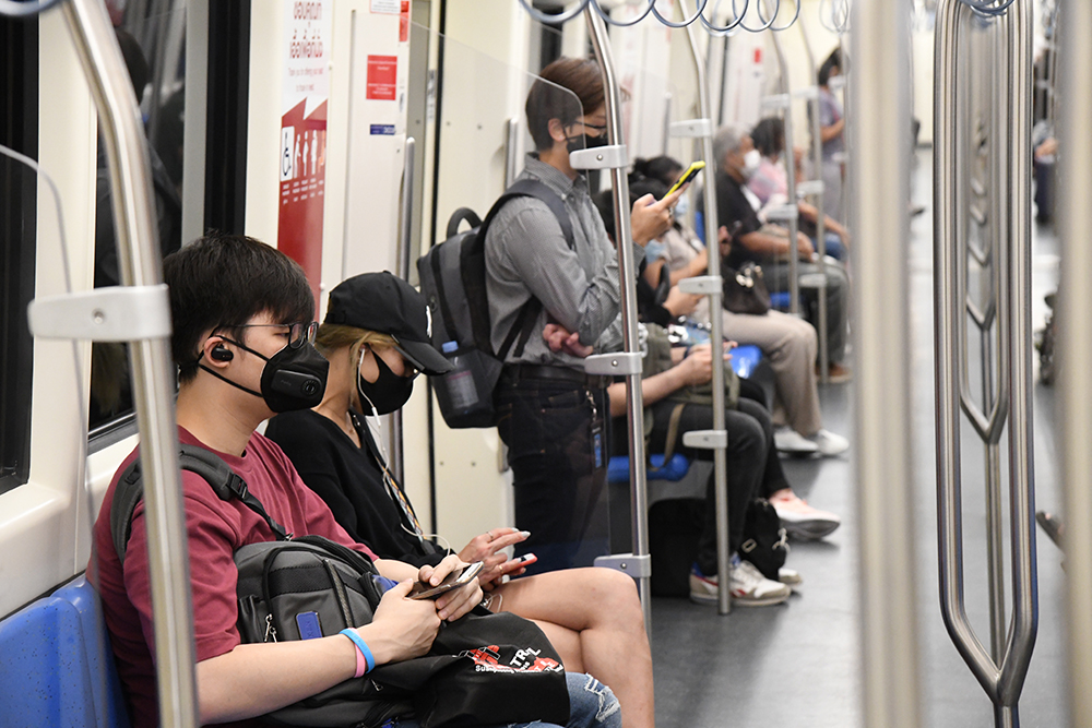 Commuters wear masks while riding a MRT train.