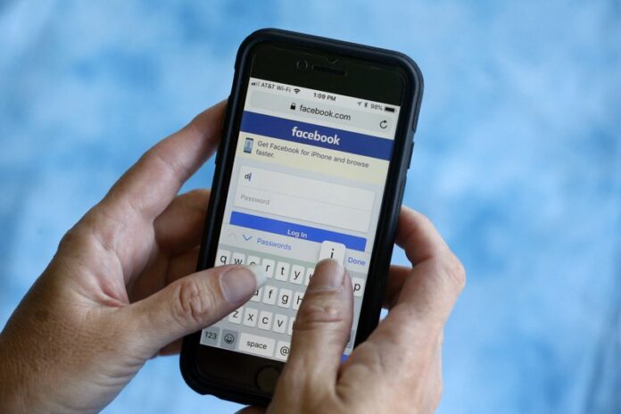 In this Aug. 21, 2018, file photo, a Facebook start page is shown on a smartphone in Surfside, Fla. Facebook says a bug in its anti-spam system is blocking the publication of links to news stories about the coronavirus. Photo: Wilfredo Lee / AP