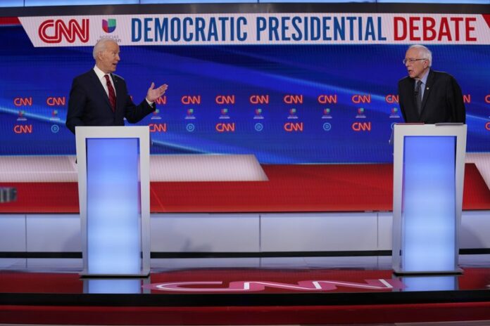Former Vice President Joe Biden, left, and Sen. Bernie Sanders, I-Vt., right, participate in a Democratic presidential primary debate at CNN Studios in Washington, Sunday, March 15, 2020. (AP Photo/Evan Vucci)