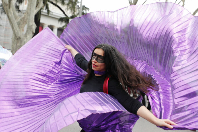 A protester dances during a march on International Women's Day in Madrid, Spain, Sunday, March 8, 2020, Thousands of women are marching in Madrid and other Spanish cities as part of International Women's Day. Photo: Paul White / AP