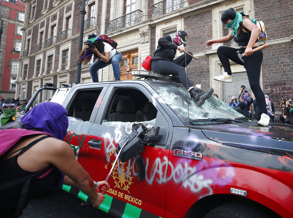 Demonstrators attack a vehicle belonging to the fire department during an International Women's Day march in Mexico City's main square, the Zocalo, Sunday, March 8, 2020. Protests against gender violence in Mexico have intensified in recent years amid an increase in killings of women and girls. Photo: Rebecca Blackwell / AP