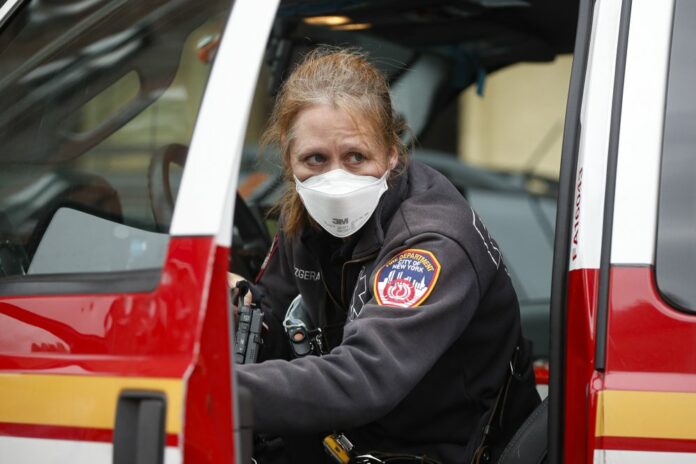 An FDNY medical worker wears personal protective equipment outside a COVID-19 testing site at Elmhurst Hospital Center, Wednesday, March 25, 2020, in New York. (AP Photo/John Minchillo)