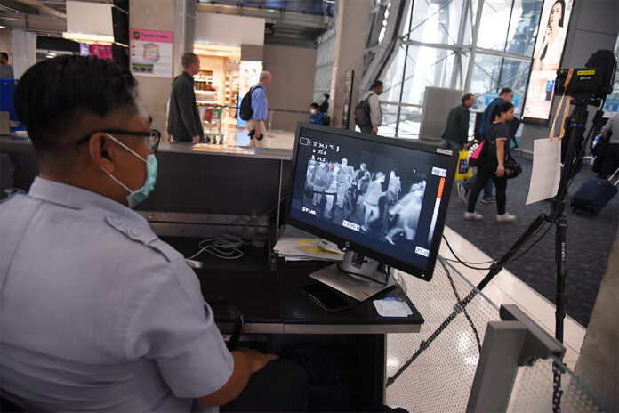 A quarantine officer screens passengers at the arrival hall of Suvarnabhumi Airport on March 4, 2020.