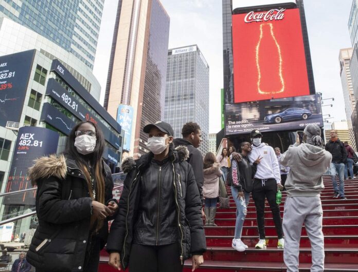 A group of visitors from Philadelphia wear masks as a precaution to the coronavirus, Wednesday, March 11, 2020, in New York's Times Square. (AP Photo/Mary Altaffer)