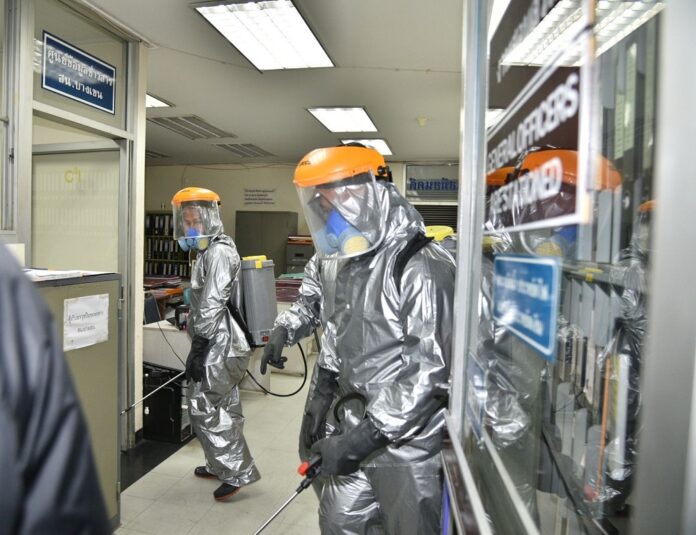 Health workers disinfect a police station in Bangkok on March 31, 2020.