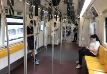 More Infections Linked to Boxing Stadium, Raising Tally to 212 Commuters wear face masks on skytrain on March 17, 2020.