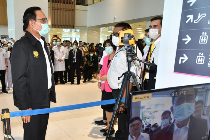 Prime Minister Prayut Chan-o-cha gets his temperature check during his visit to Rajavithi Hospital on March 12, 2020.