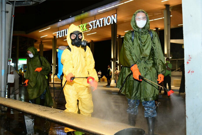 Soldiers disinfect a bus stop in front of Future Park shopping mall in Pathum Thani province on March 20, 2020.