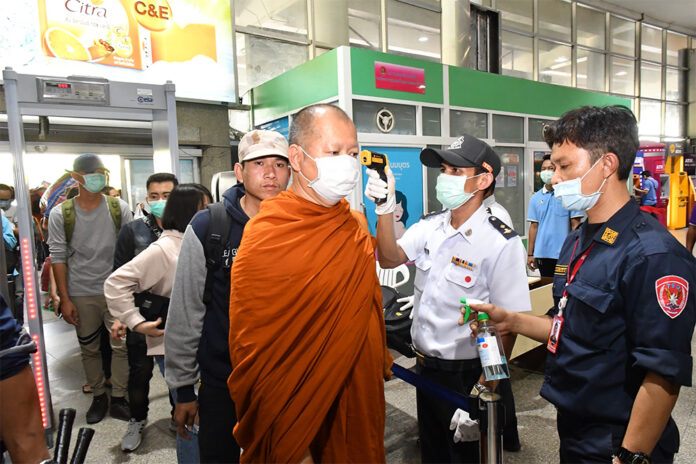 A monk gets his temperature check before entering into Mo Chit Bus Terminal on March 22, 2020.