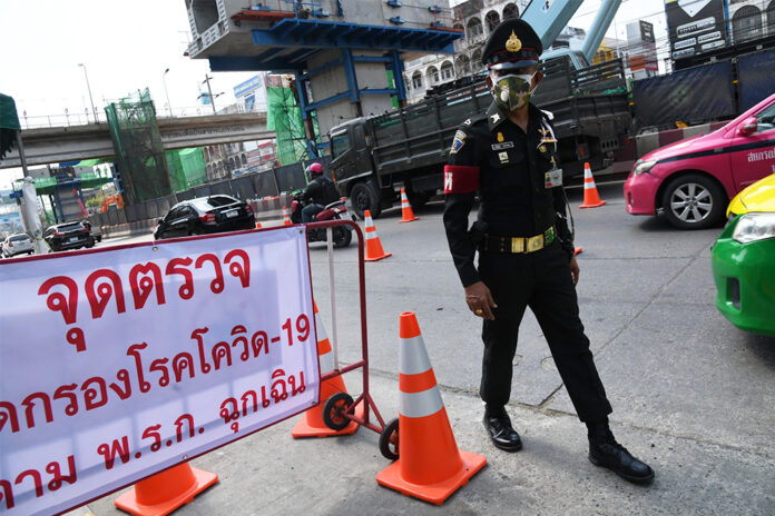 A military police officer stands guard at a coronavirus checkpoint on Chaengwattana Road.