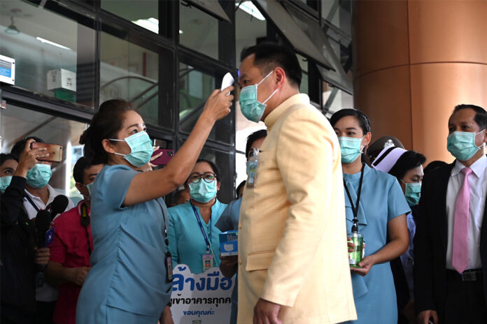 Health minister Anutin Charnvirakul gets his temperature check during his visit to Bamrasnaradura Infectious Diseases Institute on March 10, 2020.
