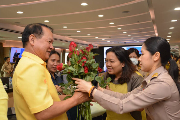 Whichai Phochanakij, left, receives roses from his staffers at the Department of Internal Trade on March 16, 2020.