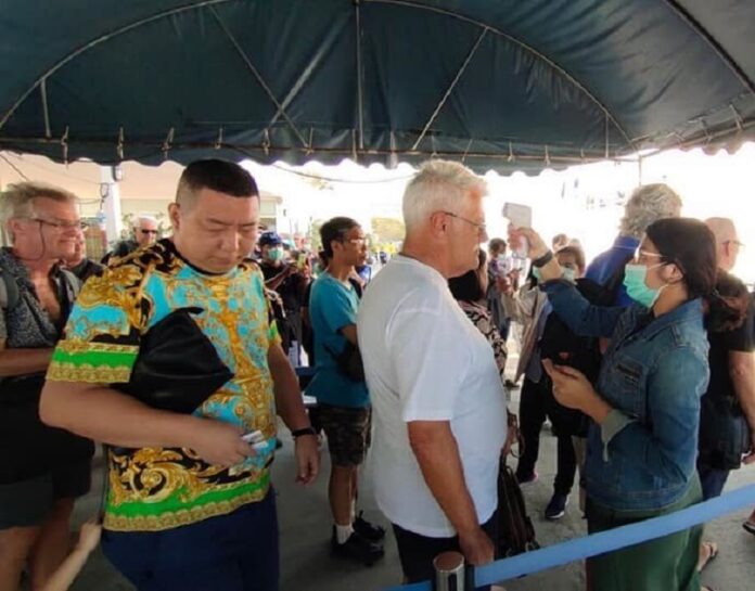 A file photo of travelers getting temperature check in Hua Hin in February, 2020.
