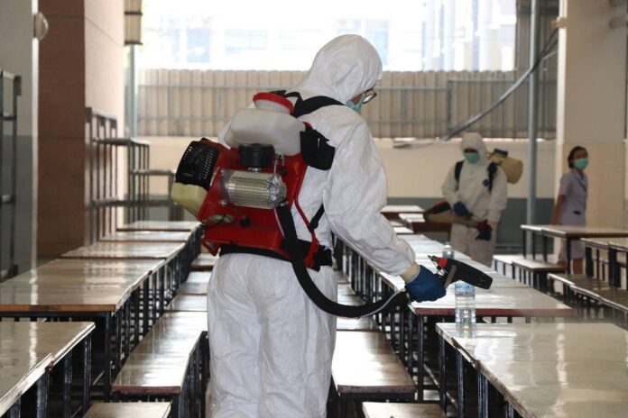City workers in hazmat suits disinfect a school in northern Bangkok on Feb. 26, 2020, after one of its students tested positive for the coronavirus.