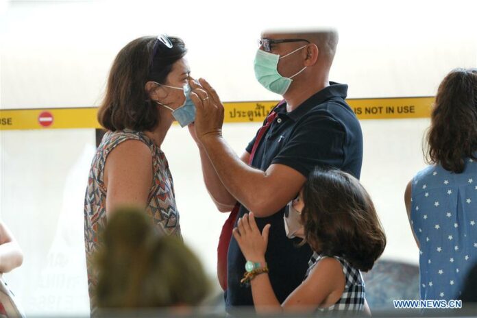 Tourists put on masks in Bangkok, Thailand, March 5, 2020. Thailand is manufacturing as many as 50 million cloth masks which will be provided for people nationwide to wear against the COVID-19 outbreak, confirmed Interior Minister Anupong Paojinda on Wednesday. (Xinhua/Rachen Sageamsak)