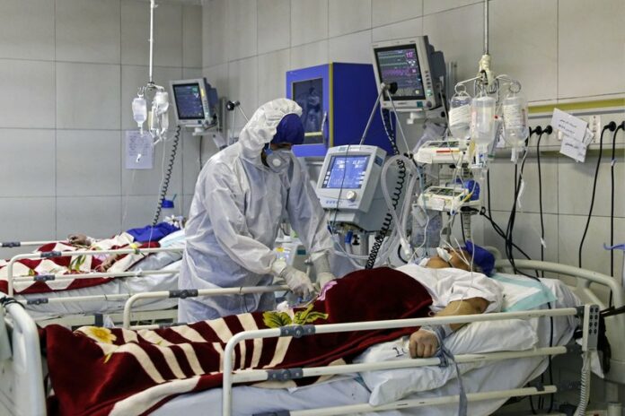 In this Sunday, March 1, 2020 photo, a medic treats a patient infected with coronavirus, at a hospital in Tehran, Iran. (Ali Shirband/Mizan News Agency via AP)