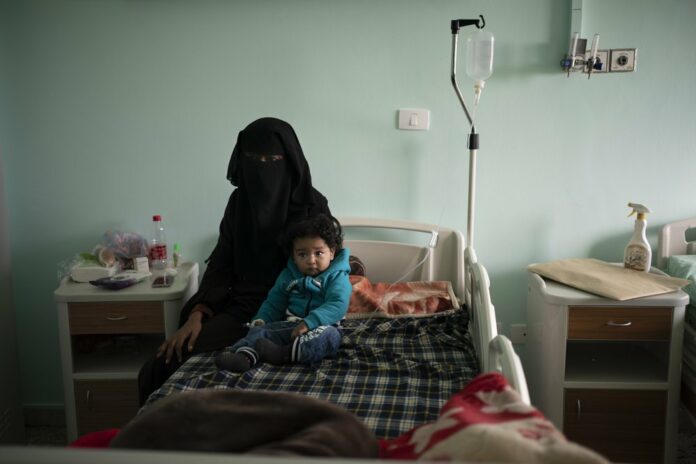 In this Feb. 27, 2020 file photo, Yazan, 1, sits with his mother before his heart surgery at the Tajoura National Heart Center in Tripoli, Libya. (AP Photo/Felipe Dana, File)