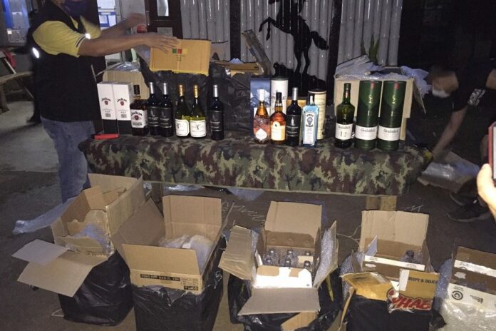 Security officers show a cache of alcohol reportedly seized from smugglers on April 27, 2020.