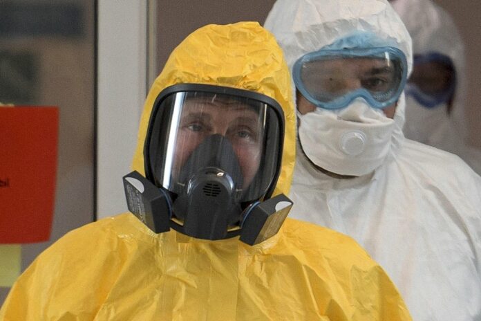 In this file photo taken on Tuesday, March 24, 2020, Russian President Vladimir Putin wearing a protective suit enters a hall during his visit to the hospital for coronavirus patients in Kommunarka, outside Moscow, Russia. (Alexei Druzhinin, Sputnik, Kremlin Pool Photo via AP, File)