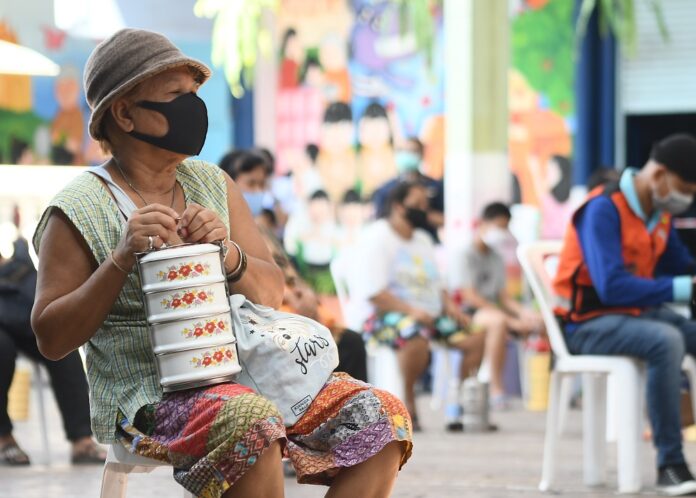Residents in Don Mueang district of Bangkok queue up for food donations on April 21, 2020.