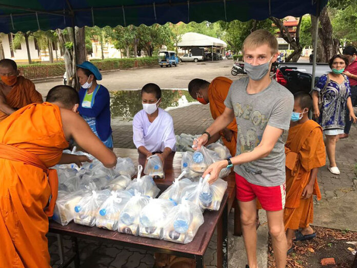 Ivan, right, holds donations at Wat Pattanaram Phra Aram Luang.