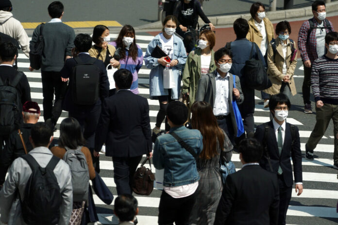 People with protective masks cross a pedestrian walkway Thursday, April 9, 2020, in Tokyo. Japanese Prime Minister Shinzo Abe declared a state of emergency last Tuesday for Tokyo and six other prefectures to ramp up defenses against the spread of the coronavirus. Photo: Eugene Hoshiko / AP