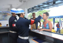 Gov’t Says Private Hospitals Can’t Charge COVID-19 Treatment A foreign tourist gets her temperature checked by military police officers at Ao Manao in Prachuap Khiri Khan province on March 19, 2020.