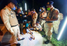 7,000 Curfew Arrests Made Over the Past Two Weeks: Police Security officials in Trang province arrest two men for possession of amphetamine and a bottle of kratom cocktail at a COVID-19 checkpoint on April 16, 2020.